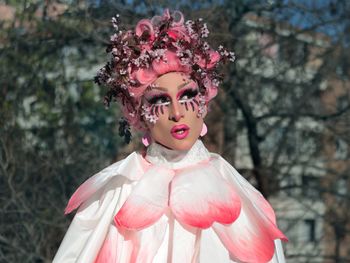 Young woman in costume standing against bare trees