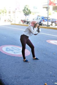 Side view of woman walking on road