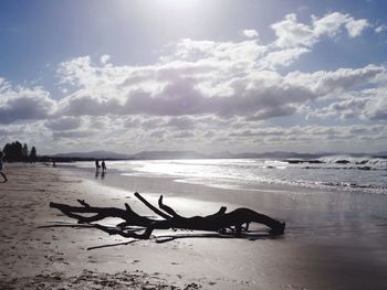 Scenic view of beach against cloudy sky