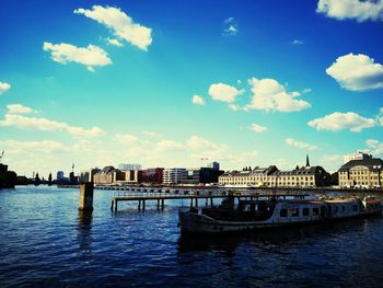 Scenic view of river by buildings against sky