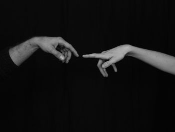 Close-up of man hand over black background