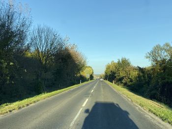 Road amidst trees against sky