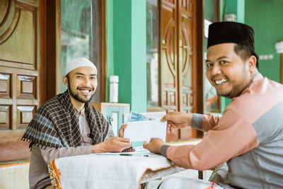 Young man doing charitable donation at mosque