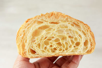 Close up croissant texture, baker hand hold half croissant show the texture inside