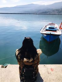 Woman with dog on sea against sky