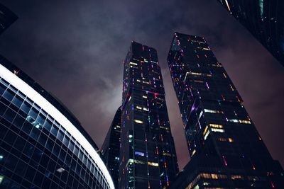 Low angle view of illuminated buildings against sky at night