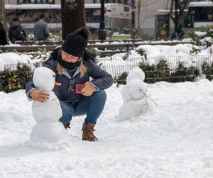 Full length of man sitting on snow