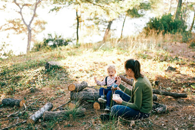 Side view of boy sitting on field