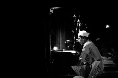 Man practicing music in darkroom