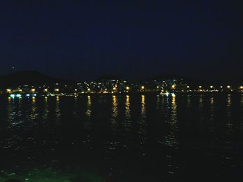 Illuminated cityscape against sky at night