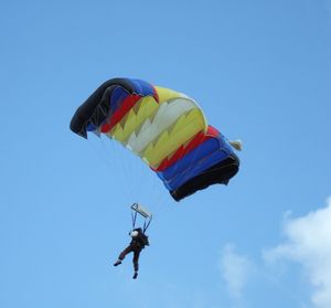 Low angle view of multi colored balloons against blue sky