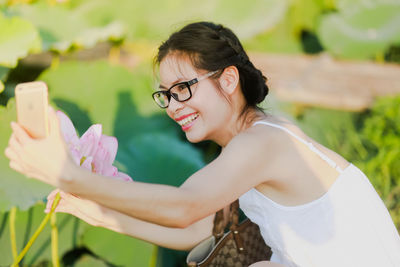 Side view of young woman looking away while standing outdoors