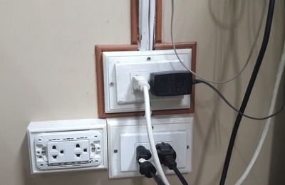 Close-up of electrical plugs connected into electrical outlet