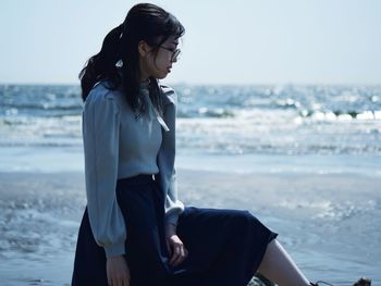 Young woman sitting on beach