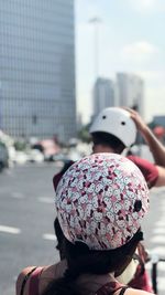 Rear view of woman on street against buildings in city