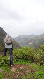 Man standing on mountain against sky