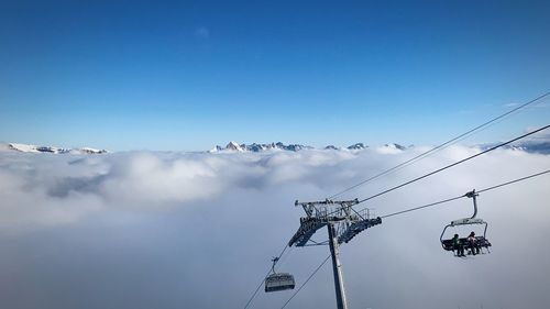 Low angle view of ski lift against blue sky