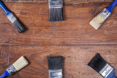 High angle view of paintbrushes on wooden floor
