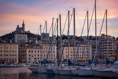 Sailboats in city at sunset