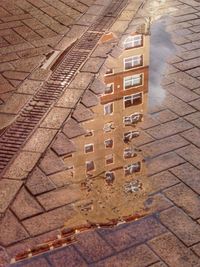 Reflection of built structure in puddle