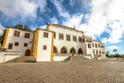 Low angle view of historical building against cloudy sky during sunny day