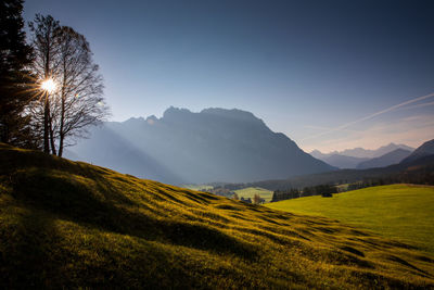 Scenic view of field and mountains against sky