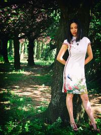 Portrait of woman standing by tree