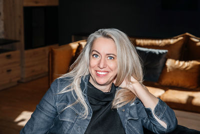 Contemplative mature woman lounging in a dark room with soft lighting