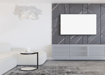 Led tv with blank white screen, hanging on the wall at home. tv mock up. copy space 