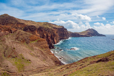 Scenic view of sea and mountains against sky