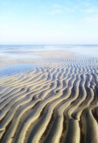 Surface level of sandy beach against sky