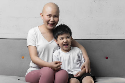 Happy mother and daughter sitting on floor