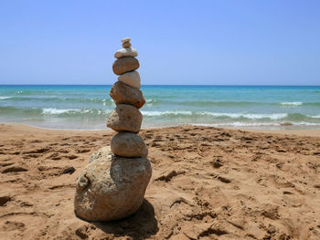 Stack of stones on beach against clear sky