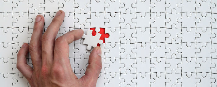 Close-up of hand arranging jigsaw puzzle