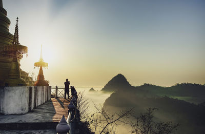 Man standing on mountain against sky during sunset