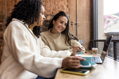 Freelancers looking at laptop in cafe