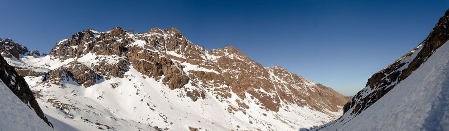 Scenic view of snowcapped mountains against clear blue sky