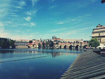 Bridge over river against buildings in city