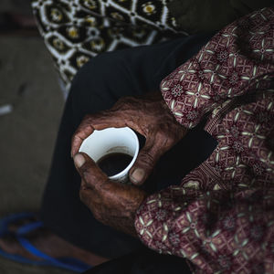 Midsection of man holding coffee cup