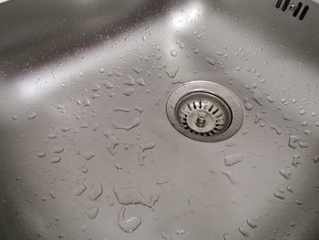 Close-up of water drops on metal grate at home