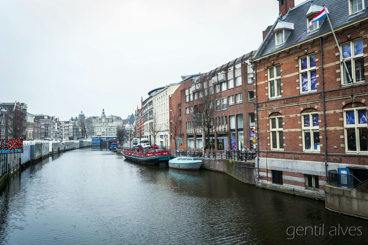 architecture, building exterior, built structure, canal, transportation, water, waterfront, nautical vessel, city, mode of transport, river, building, residential structure, residential building, boat, sky, connection, day, clear sky, bridge - man made structure