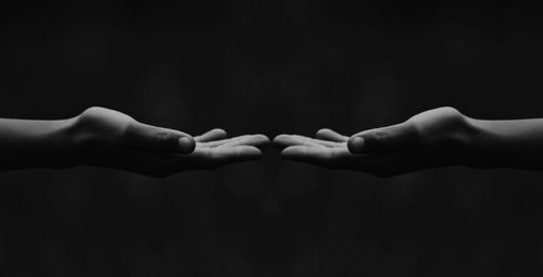 Cropped hands against black background