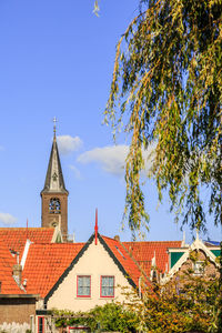 Low angle view of trees and building against sky