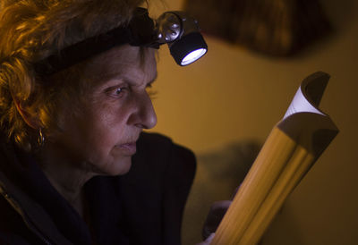 Close-up of senior woman reading book at home