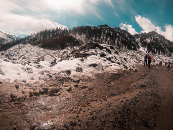 People on mountain road against sky