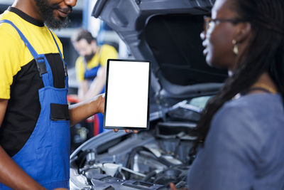 Rear view of man working in car