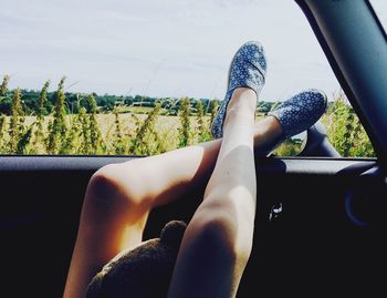 Low section of woman sitting in car