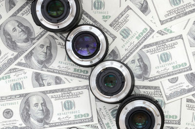 Directly above shot of camera lens on paper currency