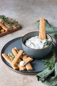 Blue cheese dressing or dip sauce with rosemary and gingerbread cookies sticks.