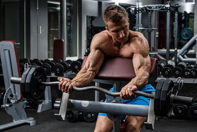 Shirtless man exercising in gym